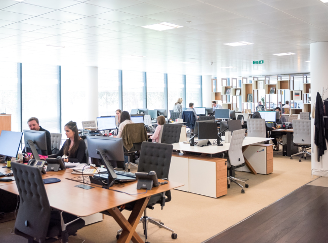 オフィスで数人がパソコン作業している画像